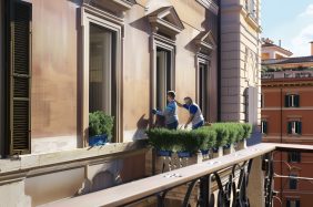 Operai installano nuove finestre su edificio a Roma.