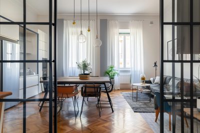 Interno moderno con porte scorrevoli in vetro affacciate su soggiorno e cucina.