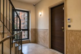 Entrata di un condominio con porta blindata e videocamera di sicurezza.